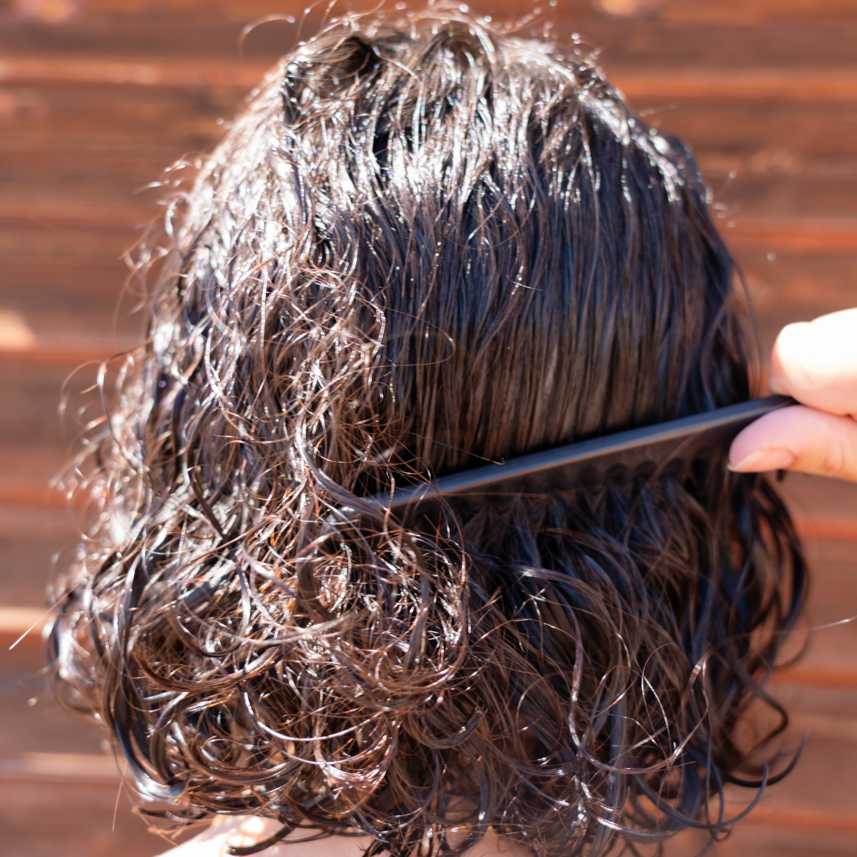 Capelli ricci idratati e luminosi al sole, protetti da originae con ingredienti vegetali e formula delicata